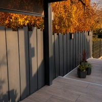 Clôture aluminium Aluroc gris anthracite à lames verticales de hauteurs différentes sur une terrasse