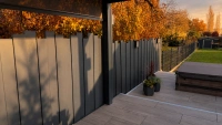 Clôture aluminium Aluroc gris anthracite à lames verticales de hauteurs différentes sur une terrasse